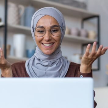 Video call online meeting with friends, young beautiful muslim woman in hijab looking at camera and